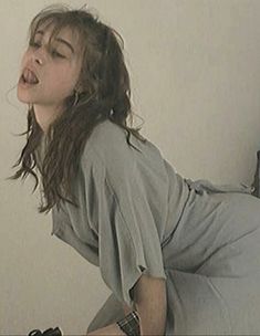 a woman laying on top of a bed with her mouth open