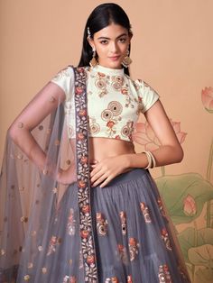 Perfectly pretty and eye-catchy gracefully adorned with this attractive grey color lehenga is formed with net material designed with mirror work, thread embroidery, and sequin work. This grey lehenga arrives with a ivory color art silk material choli made with embroidery and mirror work. It also comes with a grey color net material dupatta created with thread embroidery and sequin work. This grey lehenga is stitched and can be customized up to 42 inches. The choli will be fully stitched material Sangeet Function, Grey Lehenga, Flared Lehenga, Ghaghra Choli, Embroidery Mirror, Bridesmaid Lehenga, Mirror Work Blouse, Grey Mirror, Lehenga Fabric