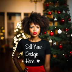 a woman standing in front of a christmas tree wearing a t - shirt that says sell your design here