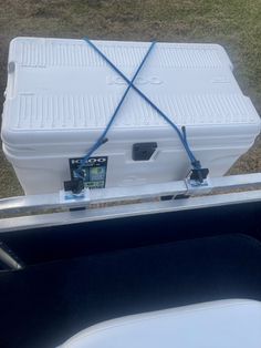 a white cooler sitting on top of a grass covered field