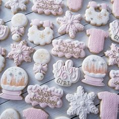 many decorated cookies on a table with snowflakes and frosted ones in the background