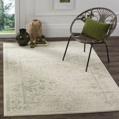 a living room area with a chair and rug on the hardwood floor, along with an open window