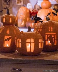 carved pumpkins with lit windows and bats on them