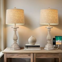 two lamps sitting on top of a wooden table