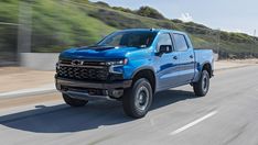 a blue chevrolet truck driving down the road