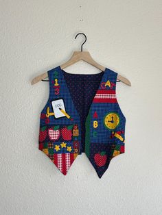 Vintage 90's handmade Back to School vest. Size- estimated kids 6/8. please check measurements. Length- 14 in in back, 19 in in front Width- 16 in ptp  Excellent vintage condition. Buttons are for decoration. Retro Cotton Patchwork Vest, Retro Multicolor Cotton Vest, School Themes, Kids Tops, Halloween Shopping, Gender Neutral, Kids Outfits, Beauty Book, Bathing Beauties