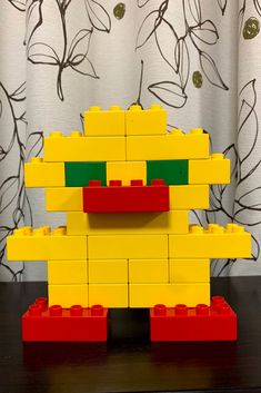 a lego toy is made to look like an angry bird with green eyes and yellow beak