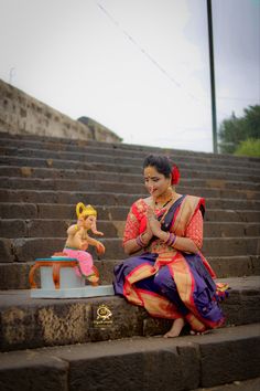 a woman sitting on steps next to a baby doll