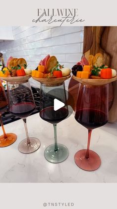 three wine glasses filled with different types of food on top of a white countertop