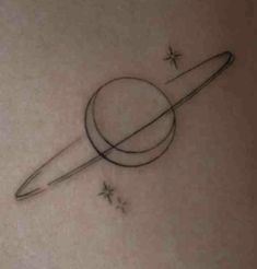 a saturn tattoo on the back of a woman's stomach, with stars around it