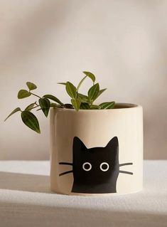 a black cat planter with green plants in it