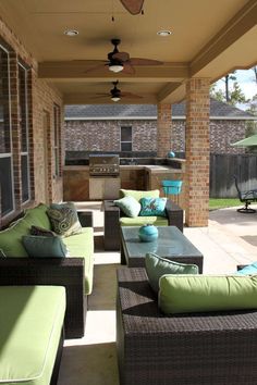 an outdoor living area with couches, tables and umbrellas