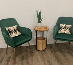 two green chairs sitting next to each other on top of a hard wood floored floor