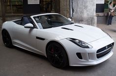 a white sports car parked in front of a building