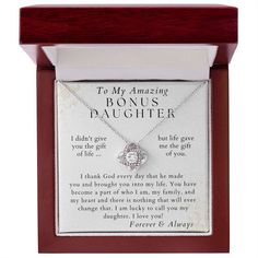 a wooden frame holds a necklace with an engraved message on the front and back of it