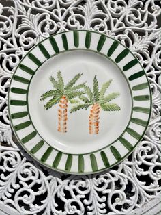 a white plate with two carrots painted on the front and back of it in green stripes