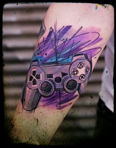 a man with a tattoo on his arm holding a video game controller