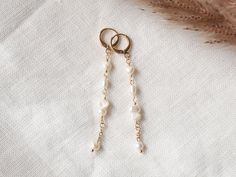 These long pearl earrings are so dainty and cute. In these 14k gold-plated earrings, there are small genuine freshwater pearls in different shapes. Lightweight, very pretty earrings.  Length: 2.8 in = 7,1 cm (including the ear wire) ♥ Jewelry care ♥ It's important to keep your jewelry dry: Take it off before taking a shower, bath, swimming or exercising. Always apply your makeup, perfume and hairspray before putting on your jewelry. Store your jewelry somewhere dry (not in the bathroom). See my whole jewelry collection: https://www.etsy.com/shop/Tazelry 14k Gold Filled Pearl White Dangle Pearl Earrings, 14k Gold Filled Single Linear Earring For Wedding, Single 14k Gold Filled Linear Earring For Weddings, Dainty Pearl Drop Linear Earrings, Delicate 14k Gold Filled Earrings With Pearl Chain, Minimalist 14k Gold Filled Linear Earrings For Wedding, Dainty Dangle Pearl Earrings With Pearl Charm, Minimalist Pearl Chain 14k Gold Filled Earrings, Minimalist Pearl Chain Earrings In 14k Gold Filled