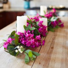 flowers and candles are lined up on a table