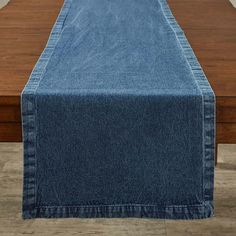 a denim table runner on top of a wooden table