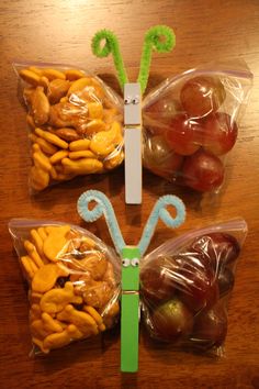 two plastic bags filled with fruits and vegetables sitting on top of a wooden table next to each other