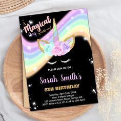 a unicorn birthday party card on a wooden plate