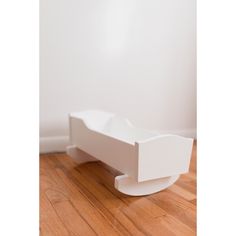 a white object sitting on top of a hard wood floor next to a white wall