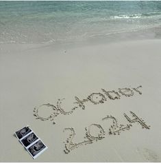 the word october 2012 is written in the sand next to an open photo album on the beach