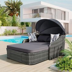 an outdoor daybed with pillows on it next to a swimming pool