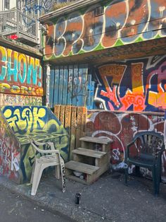 an alleyway with graffiti on the walls and steps leading up to some benches in front of it