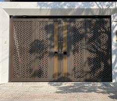 an open garage door on the side of a white building with decorative screens and windows