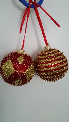 two red and gold ornaments hanging on a wall