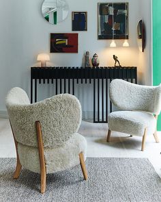 two white chairs sitting next to each other in a living room