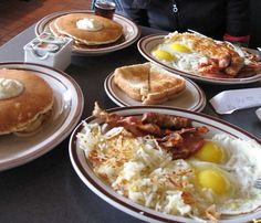 several plates of breakfast foods on a table