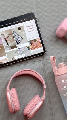 headphones, water bottle and tablet sitting on a table next to eachother