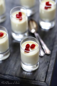 small glasses filled with pudding on top of a wooden table