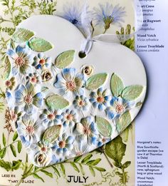 a heart shaped card with flowers and leaves on it