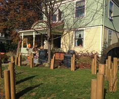 a house with wooden posts in front of it and a fence around the yard area