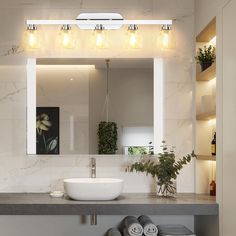 a bathroom with a sink, mirror and lights on the wall above it's counter