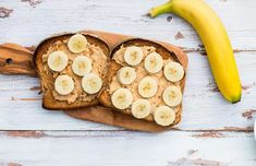 two slices of bread with peanut butter and bananas on them, next to a banana peel