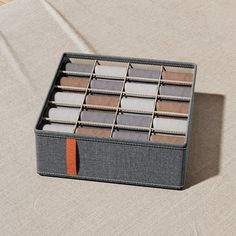 an open box containing several pairs of socks on a bed with a beige linen cover