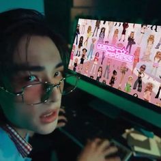 a young man wearing glasses and looking at a computer screen with barbie dolls on it