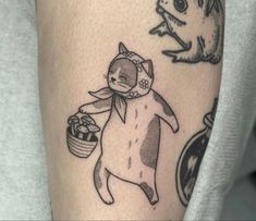 a person with a tattoo on their arm and a cat holding a basket in his hand