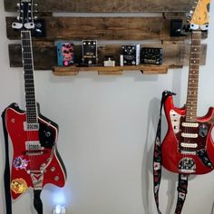 two guitars are hanging on the wall next to each other