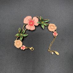 Lovely Pilgrim Danish Design floral and gold tone bracelet has lovely enamelled blooms. The two green leafy flowers have green crystal centres; two pink plastic flowers add a 1940s vibe. Adjustable; secure clasp. Excellent condition. 7-9 inches long with a two inch adjustable chain. Just beautiful!  Did you know? I can ship my products directly to your gift recipient. If items are marked as gifts, we leave out any receipt and include free giftwrapping and a handwritten note.  Follow this link  h Pink Enamel Jewelry With Flower Charm, Pink Enamel Flower-shaped Jewelry, Pink Flower Decorated Bracelet Jewelry, Pink Flower Decorated Bracelet, Pink Flower-shaped Metal Jewelry, Green Metal Flower Jewelry, Green Metal Flower-shaped Jewelry, Vintage Pink Flower Jewelry, Green Flower-shaped Enamel Jewelry