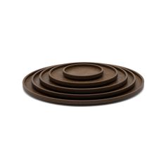 four brown plates stacked on top of each other in the shape of circles, against a white background