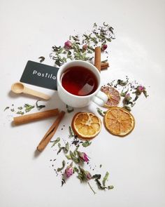 a cup of tea surrounded by dried orange slices and cinnamon sticks with a sign that reads rostilla