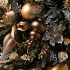 a christmas tree with gold and silver ornaments on it's branches, including an ornament