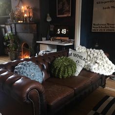 a brown leather couch sitting in a living room next to a fire place