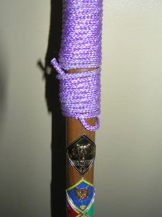 a purple rope wrapped around a wooden pole with other items attached to the top and bottom